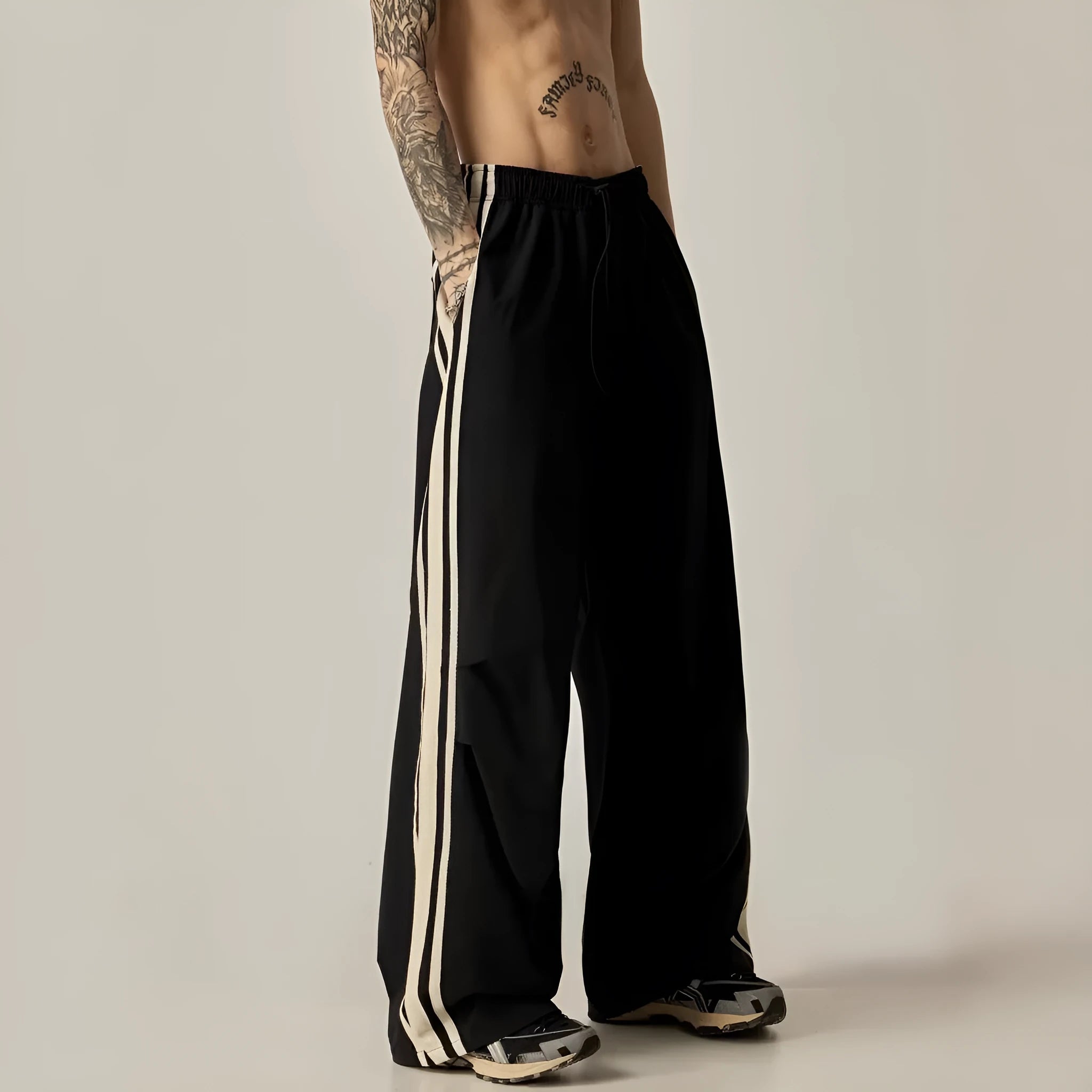 Black men's wide-leg high-waist climbing trousers laid flat, showing straight cut and polyester fabric.