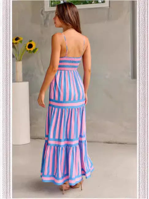 Woman wearing a striped backless suspender long dress with a square neck and side pockets.