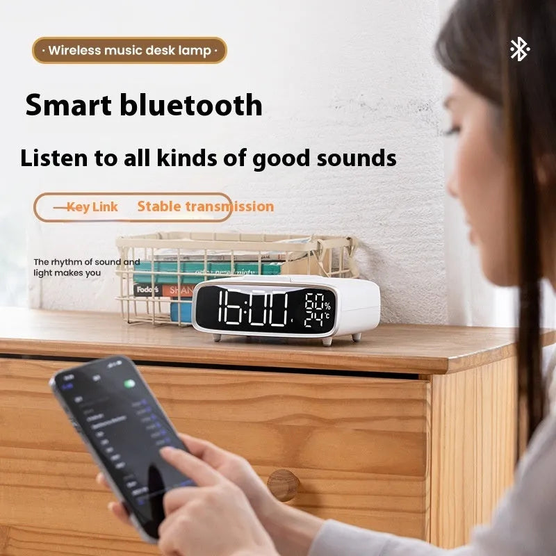 White wireless charger Bluetooth speaker with night light on desk beside smartphone