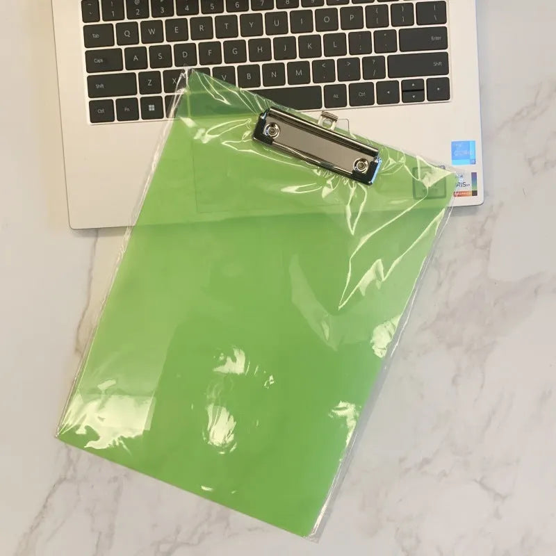 Transparent A4 plate writing board holder with metal clip, shown in blue colour on a desk.
