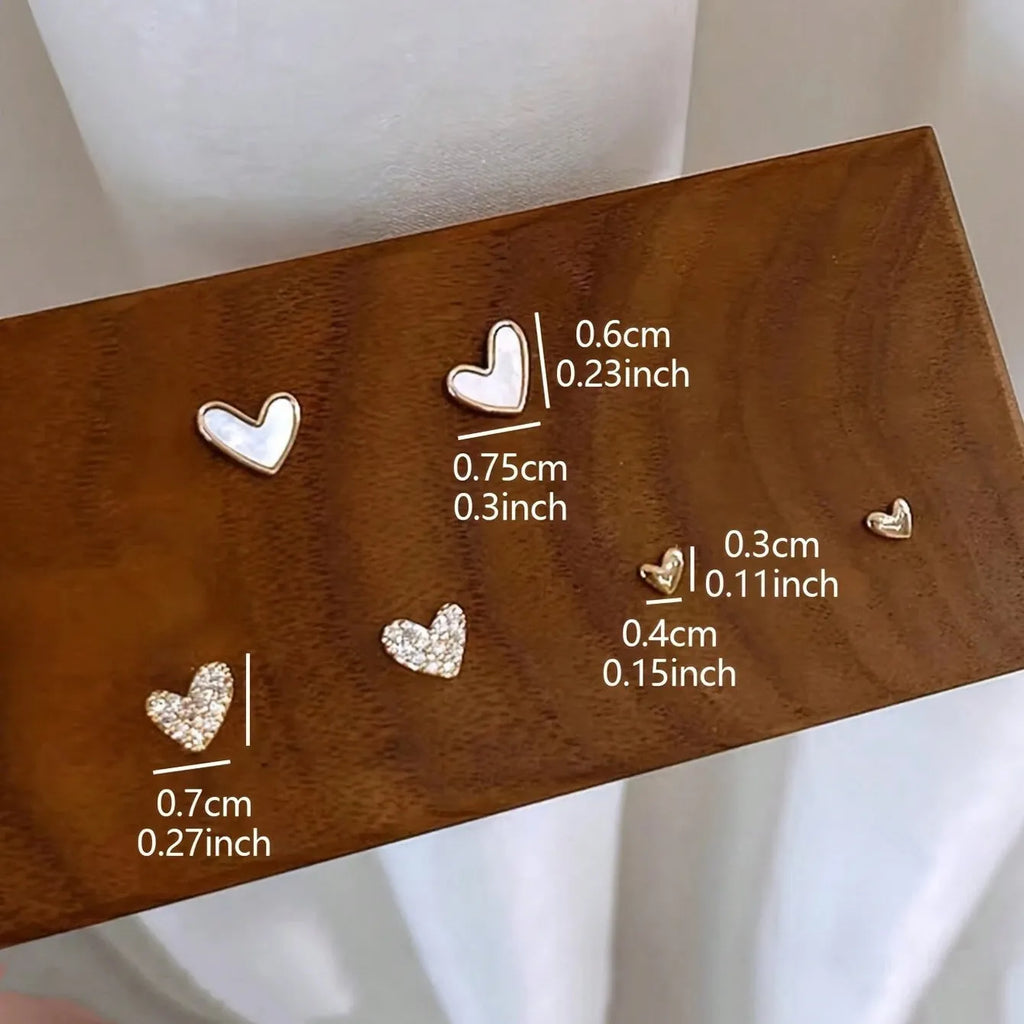 Three pairs of heart-shaped alloy earrings with electroplated finish in gold, black, and pink colours