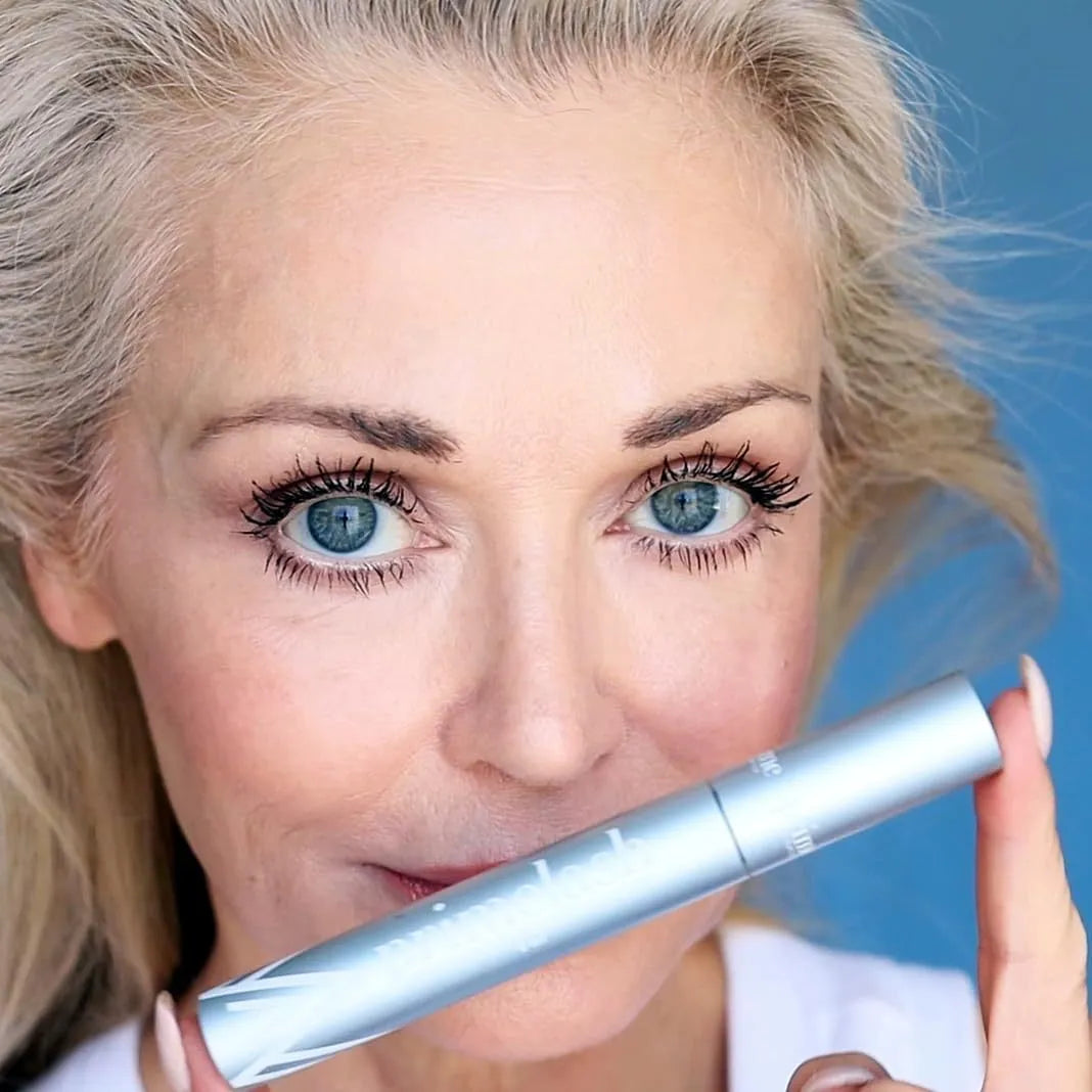 Single-piece eye black eyelash brush and comb beauty tool with 0.7g net content.