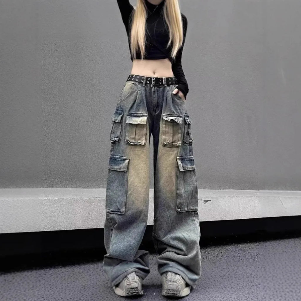 Loose-fit light blue distressed denim jeans with multiple tooling pockets on a straight-leg cut