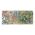 Cloth esports mouse pad with detailed floral dragon design on a desk, showing non-slip base.