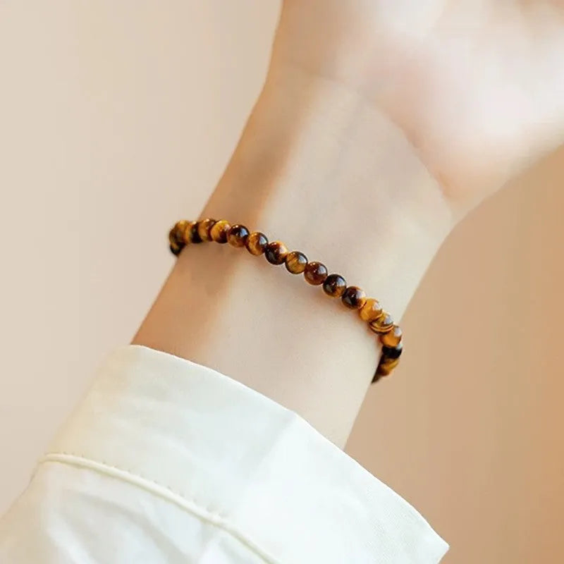 Geometric new Chinese style bracelet with round tigereye stone beads in gold and brown bands.