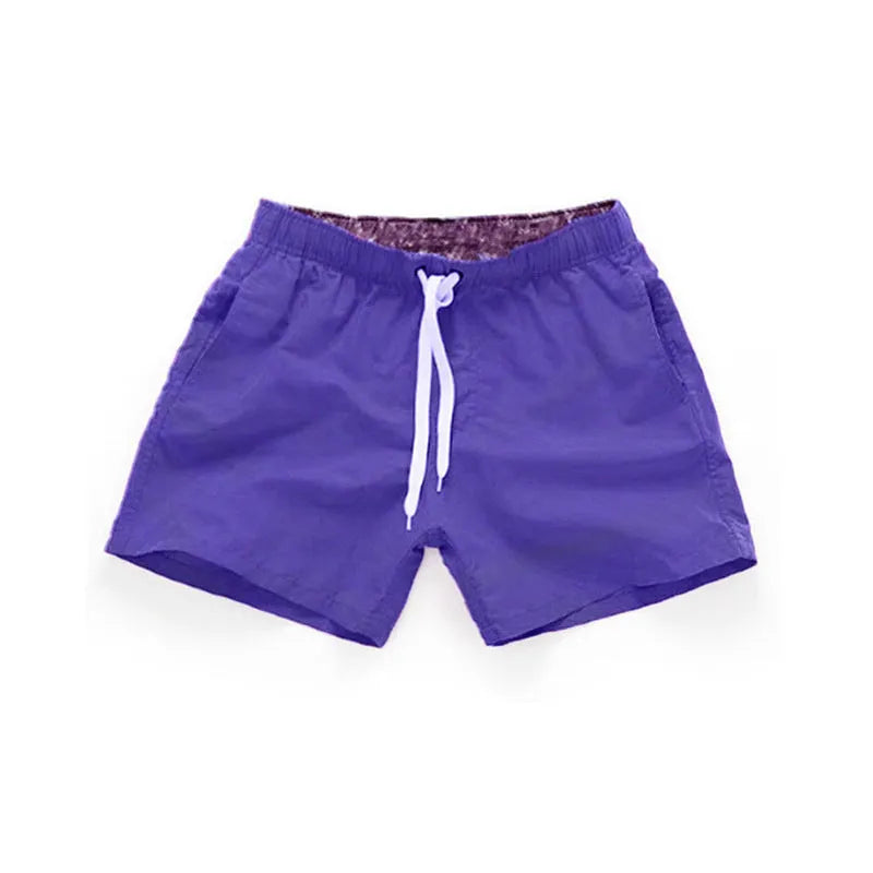 Men's straight-leg polyester beach shorts in black, shown on a model, highlighting the distressed finish and casual fit.