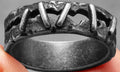 Stainless steel double ring with punk stitch patterning in dark colour, showing layered design