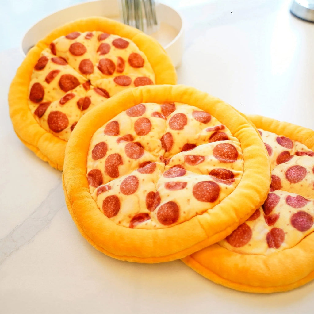 Yellow pizza slice shaped soft plush dog chew toy with squeaker on a white background.