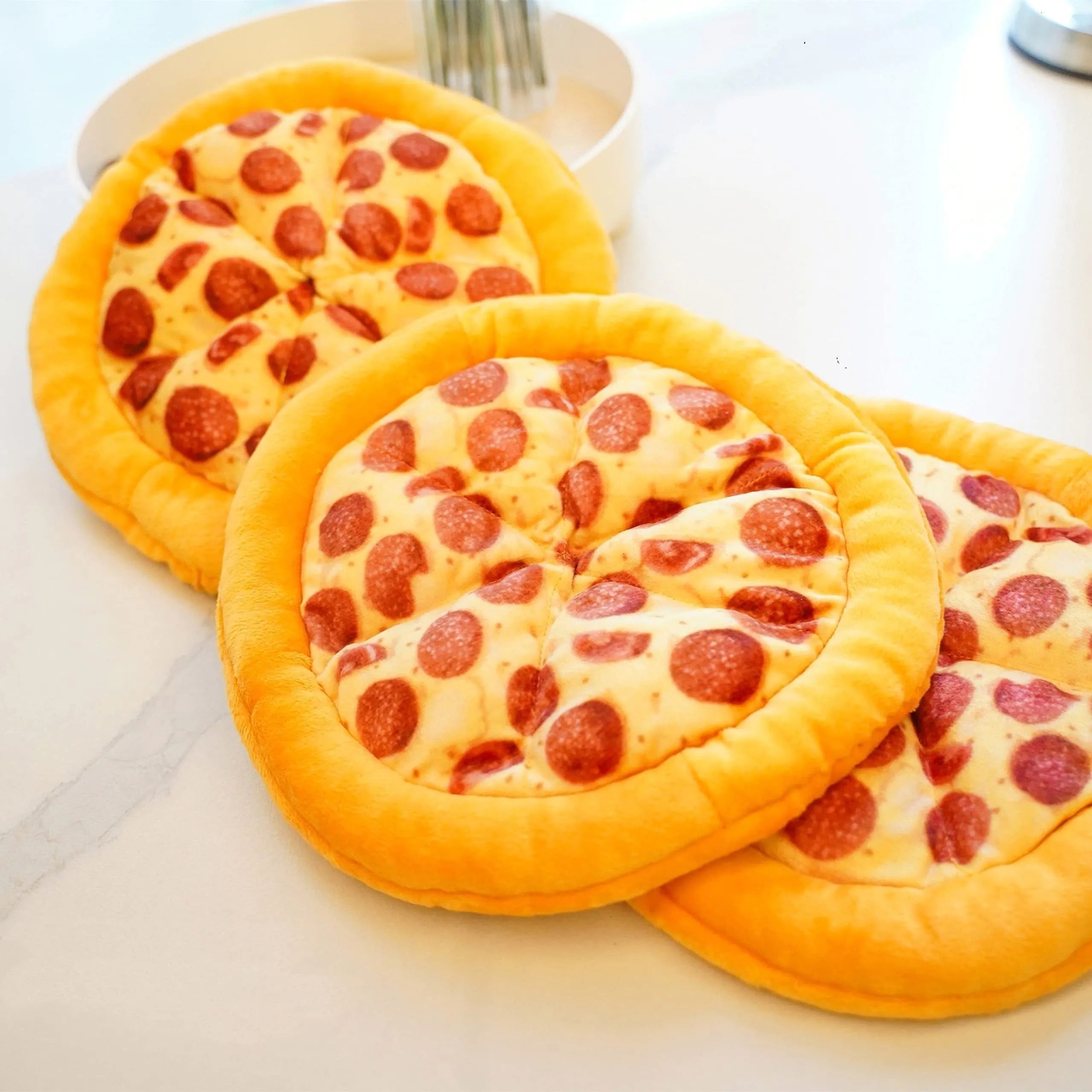 Yellow pizza slice shaped soft plush dog chew toy with squeaker on a white background.