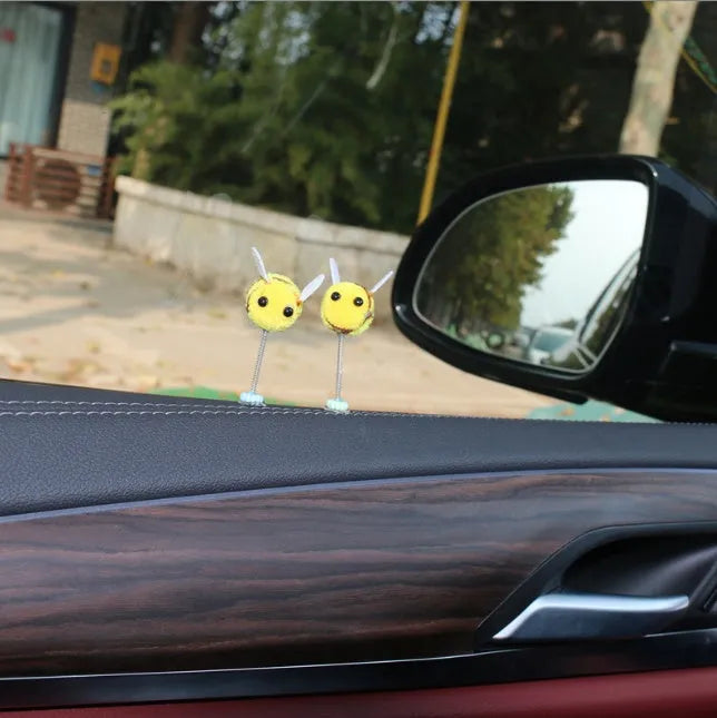 Small yellow and black fur ball bee car ornament with adhesive backing.