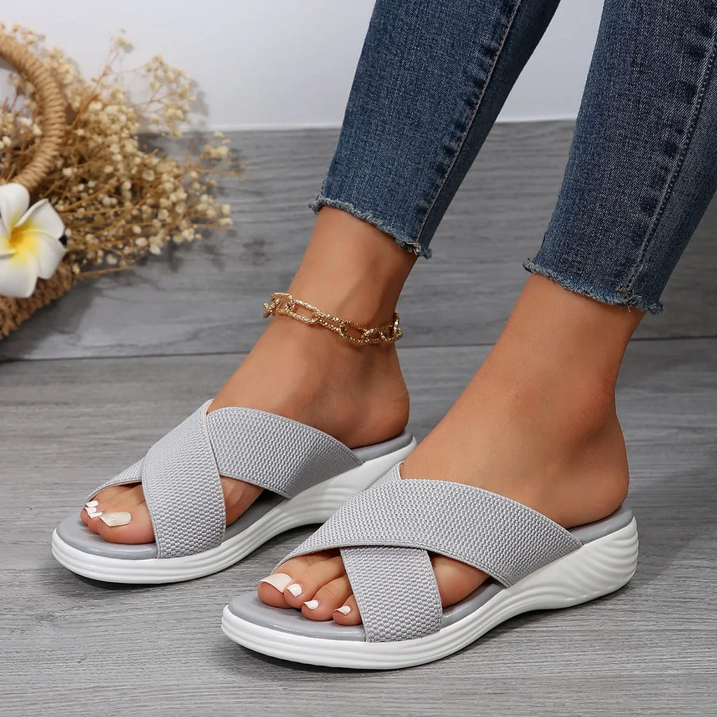 Women's black peep-toe wedge slippers with thick rubber sole showing fish mouth scaffold shape