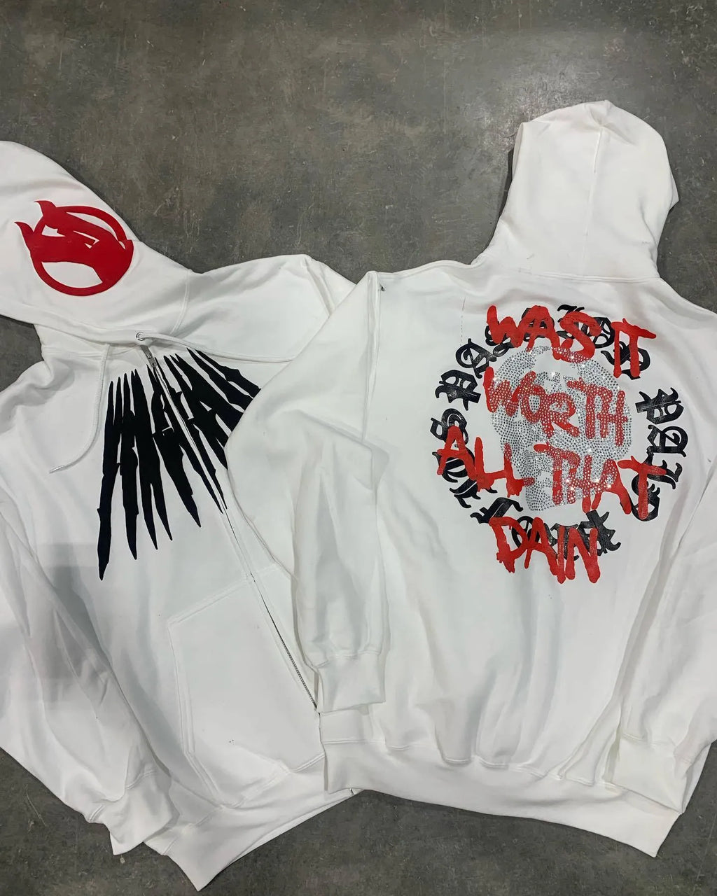 Black loose hooded sweatshirt with white printed skull design and rhinestone details on the front.