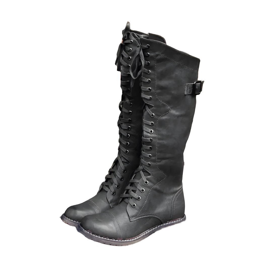 Women's black artificial PU knight boots with cross-strap and buckle fastening.