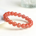Natural South cherry red agate bracelet showing polished stone beads in scattered arrangement
