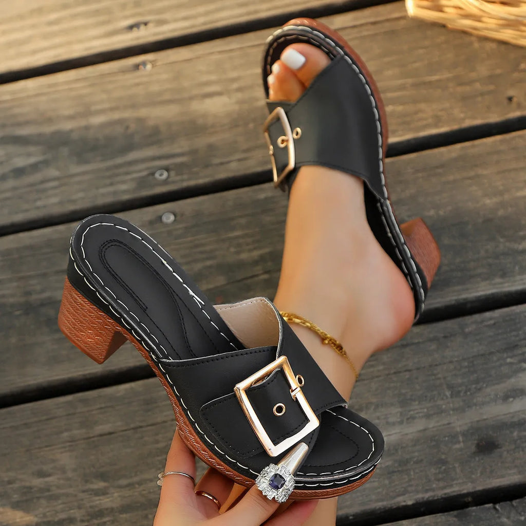 Women's black and light blue chunky heel slippers with a metal buckle closure on a rubber sole.