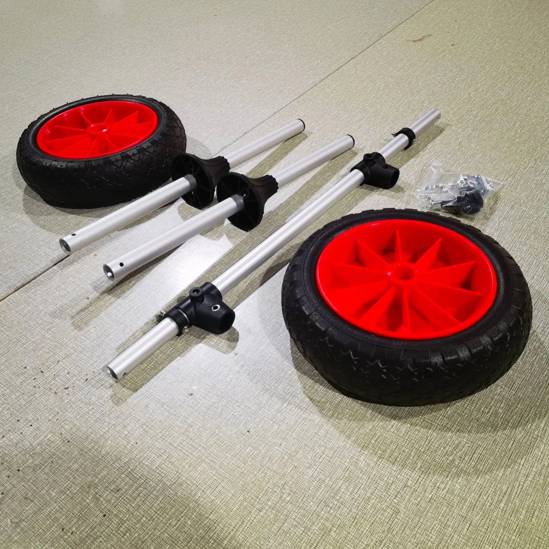 Foldable aluminium kayak cart with upright pole platform and large beach wheels for transport.