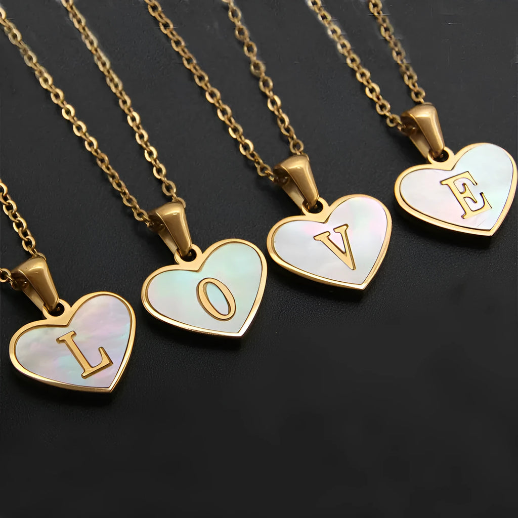 Gold-plated heart necklace with white shell pendant showing initial engraving on stainless steel chain