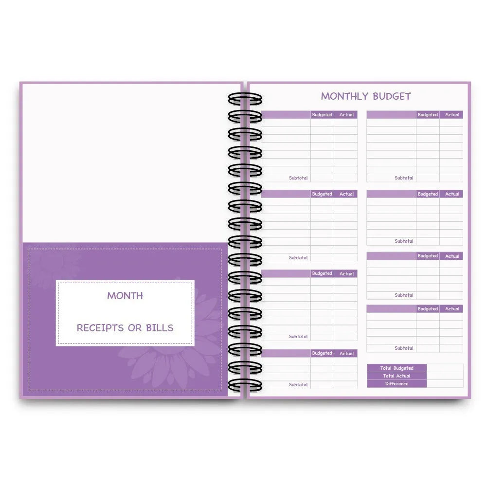 J12 Purple coil-bound monthly financial planning notebook with pen, stickers, and paper clips on a desk.