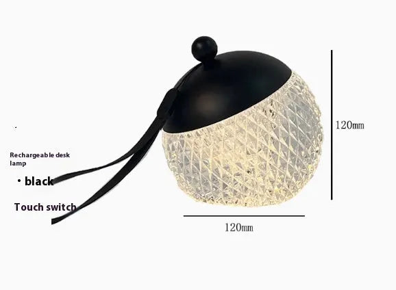Small portable dimmable night lamp in chrome finish on wooden bedside table