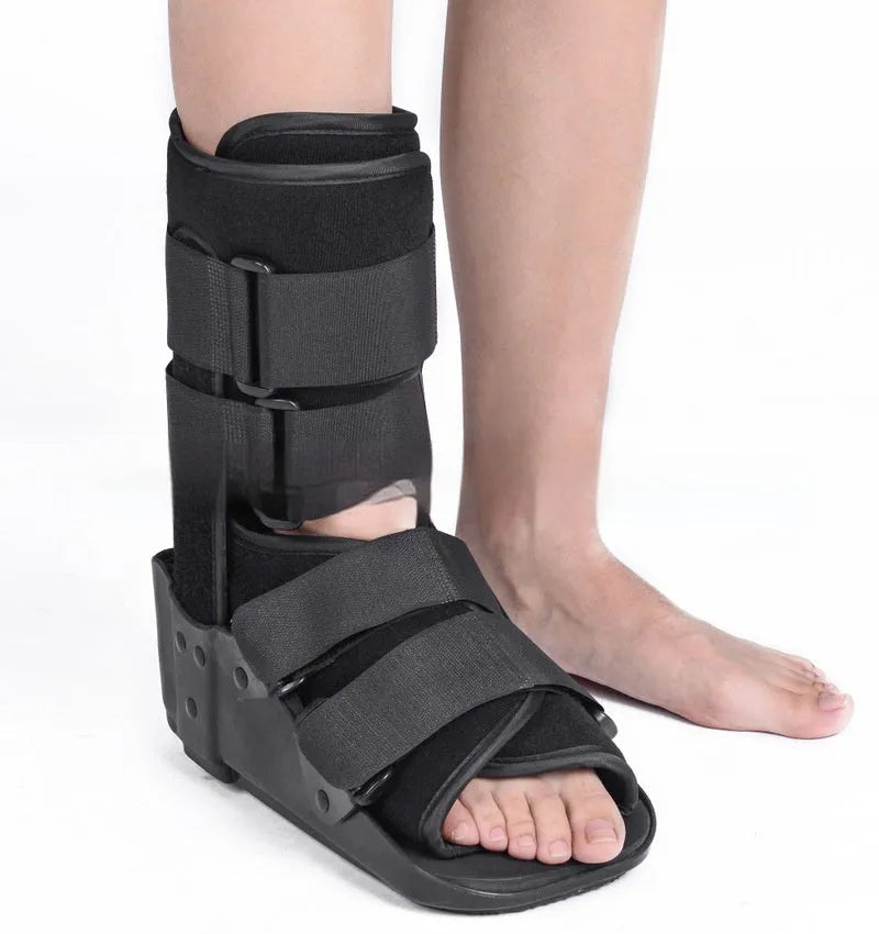 Grey achilles tendon rehabilitation boot with adjustable straps and a rigid plastic shell on a rubber sole.