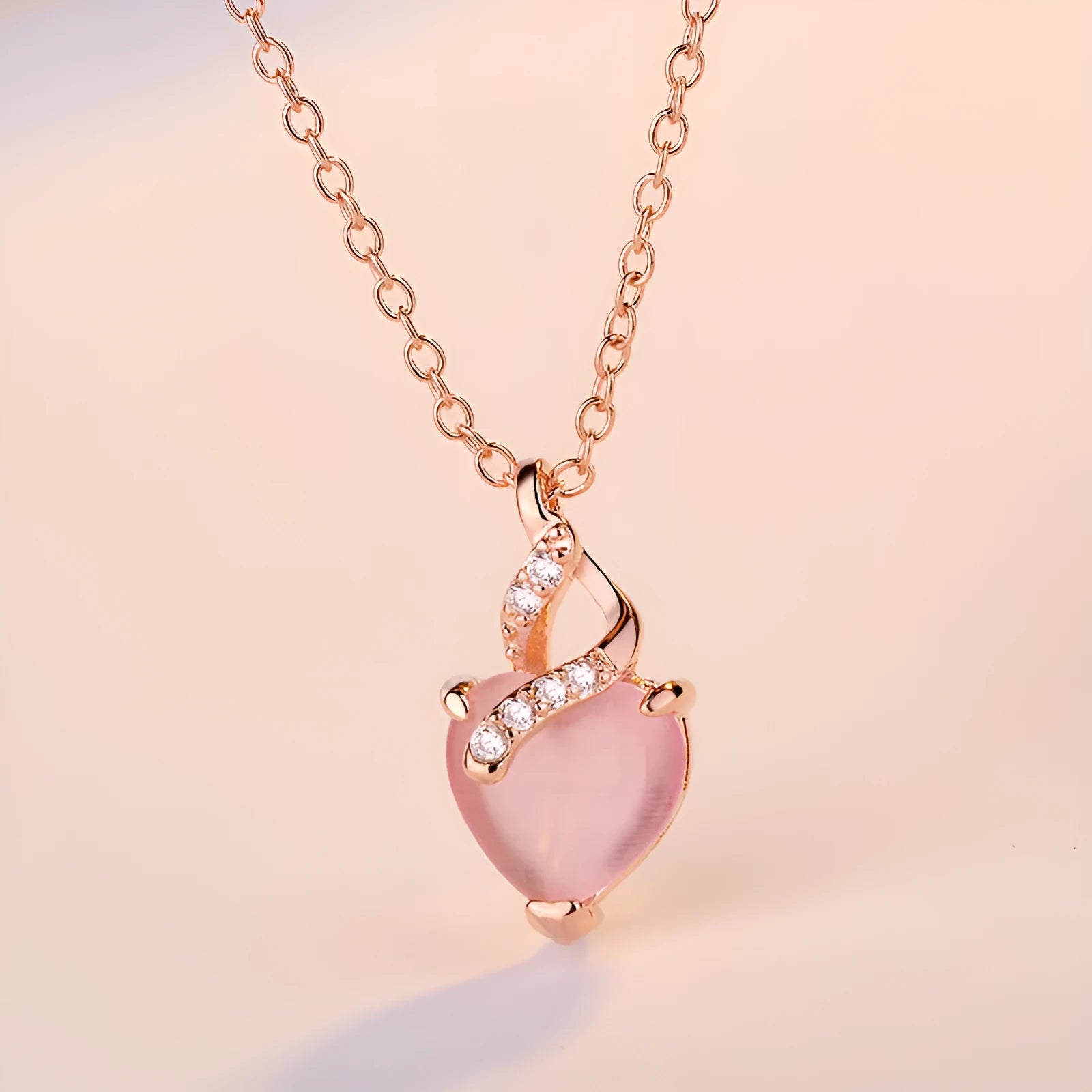 Women's necklace with heart-shaped pink crystal pendant on rose gold cross chain