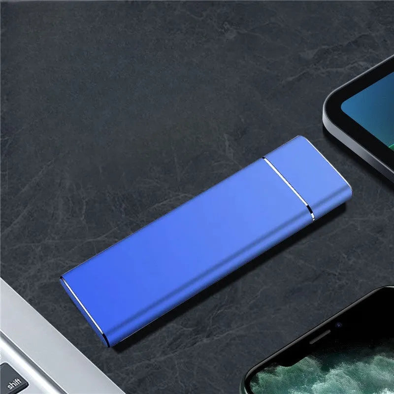 Sapphire blue metal external solid state hard disk with USB cable on a white surface