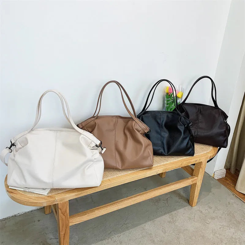 Large horizontal square soft-surface PU leather messenger bag with a long shoulder strap and zip opening.