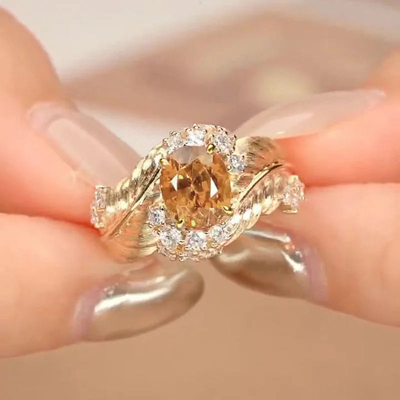 Gold-tone copper women's ring with embossed feather design and inlaid yellow zircon stones.