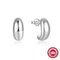 Close-up of a glossy C-shaped sterling silver stud earring in a gold electroplated finish.
